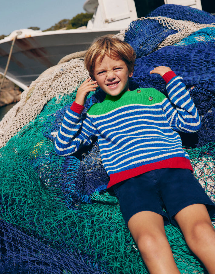 Boy wearing striped sweater laying on fishing net. Image link to Everyday Cotton Jumper.