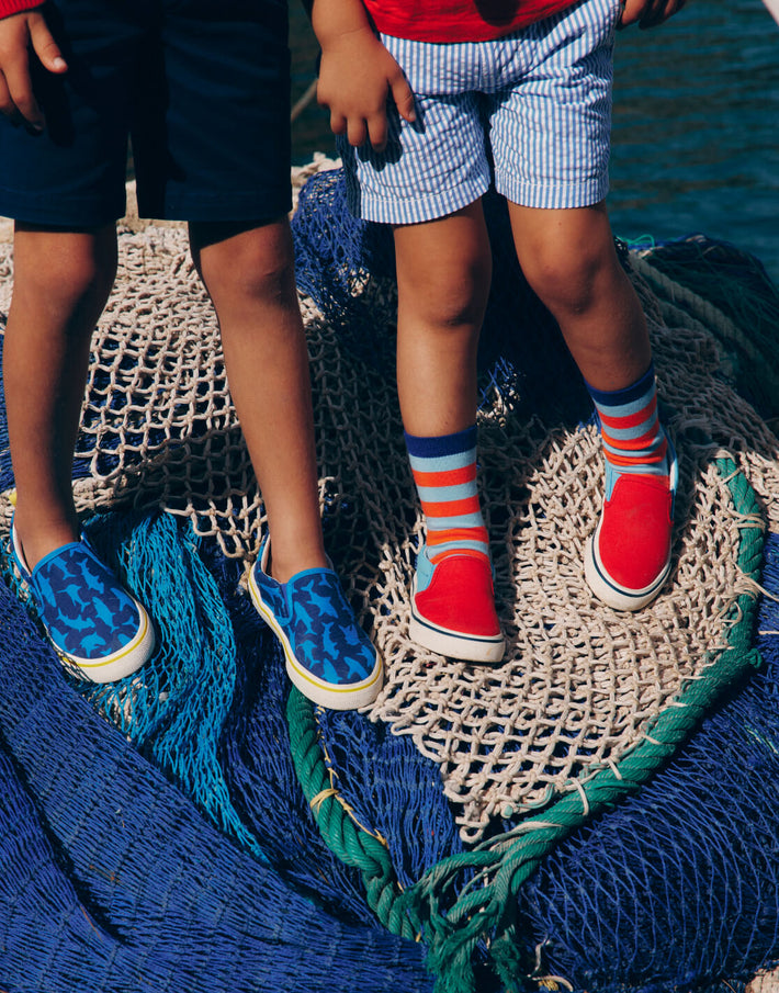 Two boys wearing slip on shoes. Image link to Canvas Slip Ons.