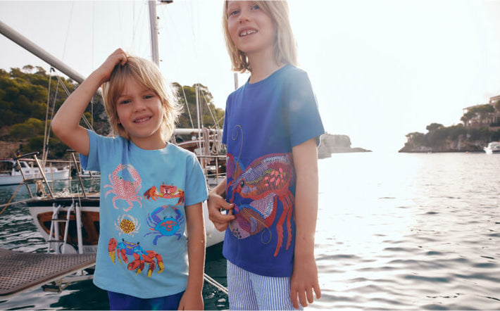 Two boys standing by the sea wearing t shirts with crustaceans on. Image link to Short Sleeve Printed T-Shirt.