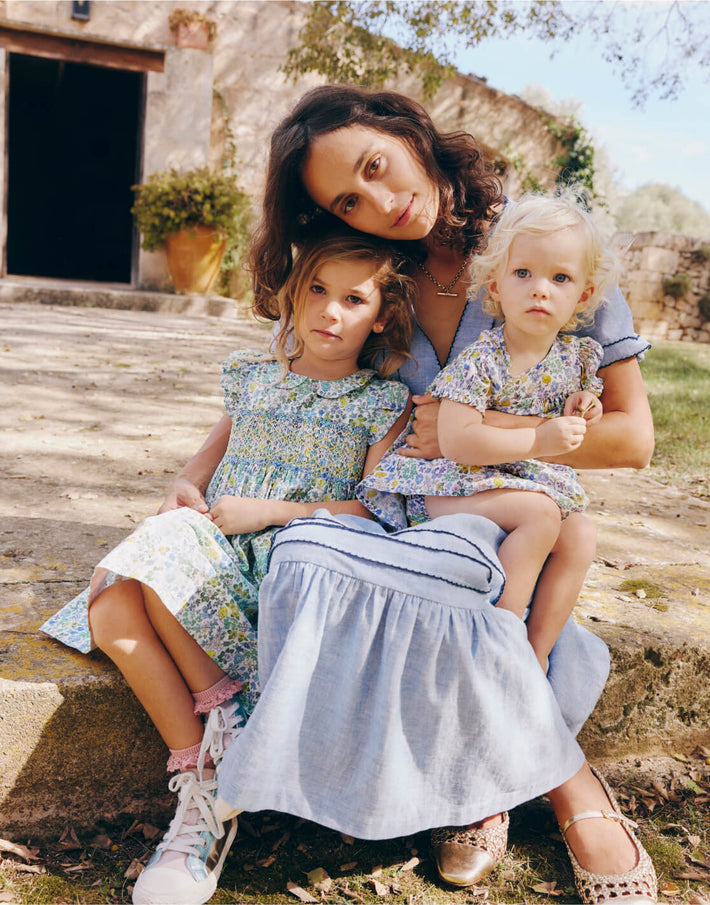 Mother and two girls wearing Boden dresses, linking to Adeline Smocked Dress - Easter Chick Floral