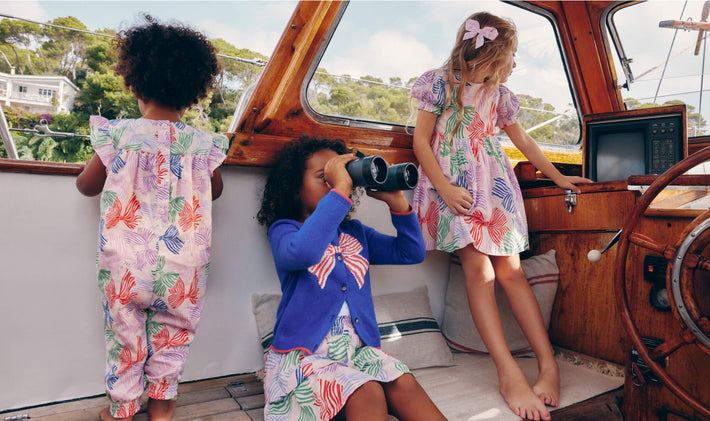 Three girls wearing matching Boden prints on a boat, linking to Tiered Woven Skirt - French Pink Bows