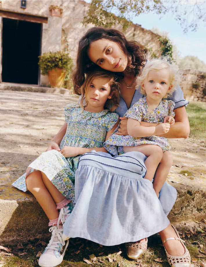 Mother and two girls wearing Boden dresses, linking to Adeline Smocked Dress - Easter Chick Floral