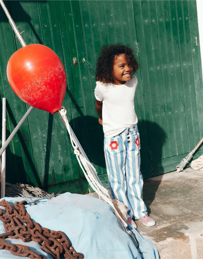 Girl standing by ship equipment. Image link to Patch Pocket Trouser.