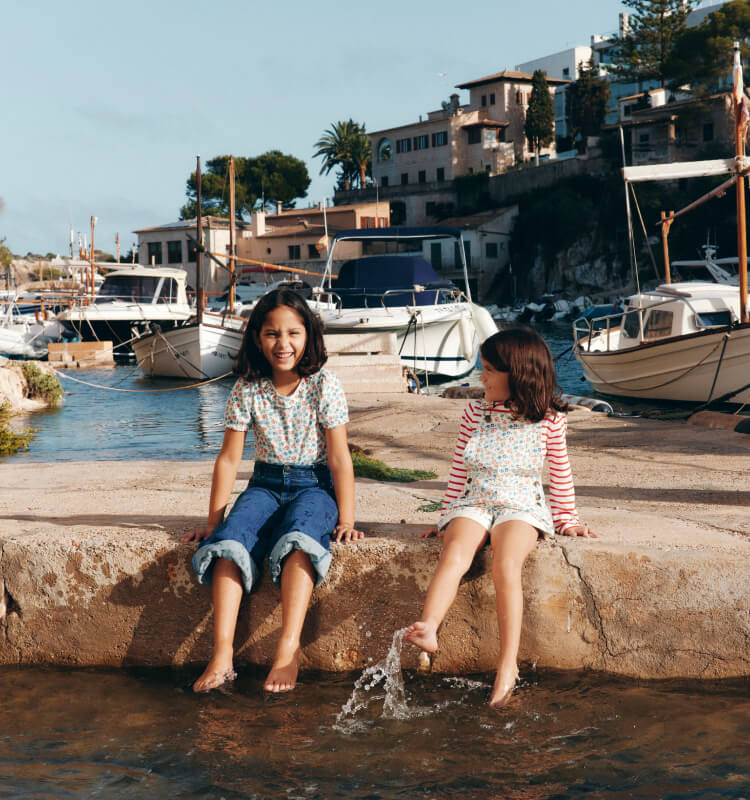 Two girls siting on a dock.