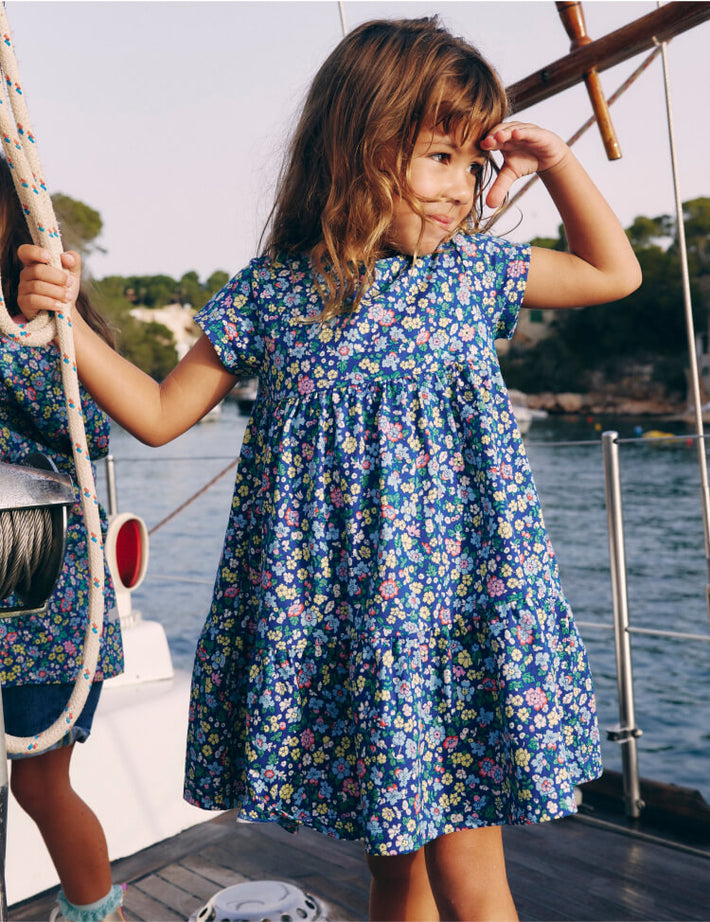 Girl standing on a boat. Image link to Ariel Twirly Jersey Dress.