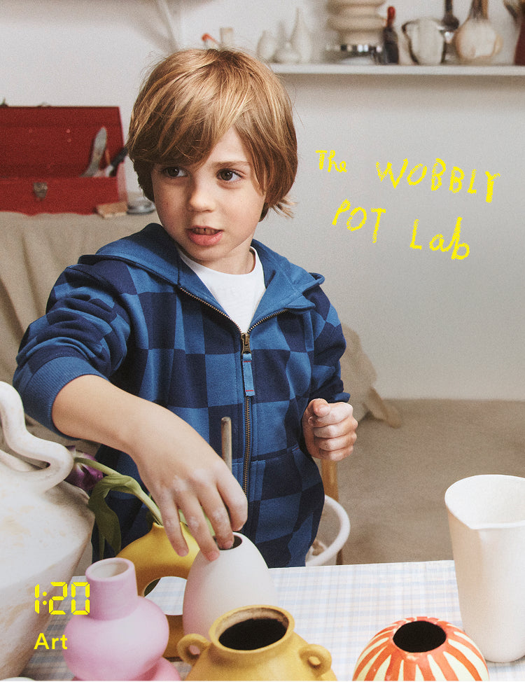 Child playing with ceramic pots in a kitchen setting, with 'The Wobbly Pot Lab' text.