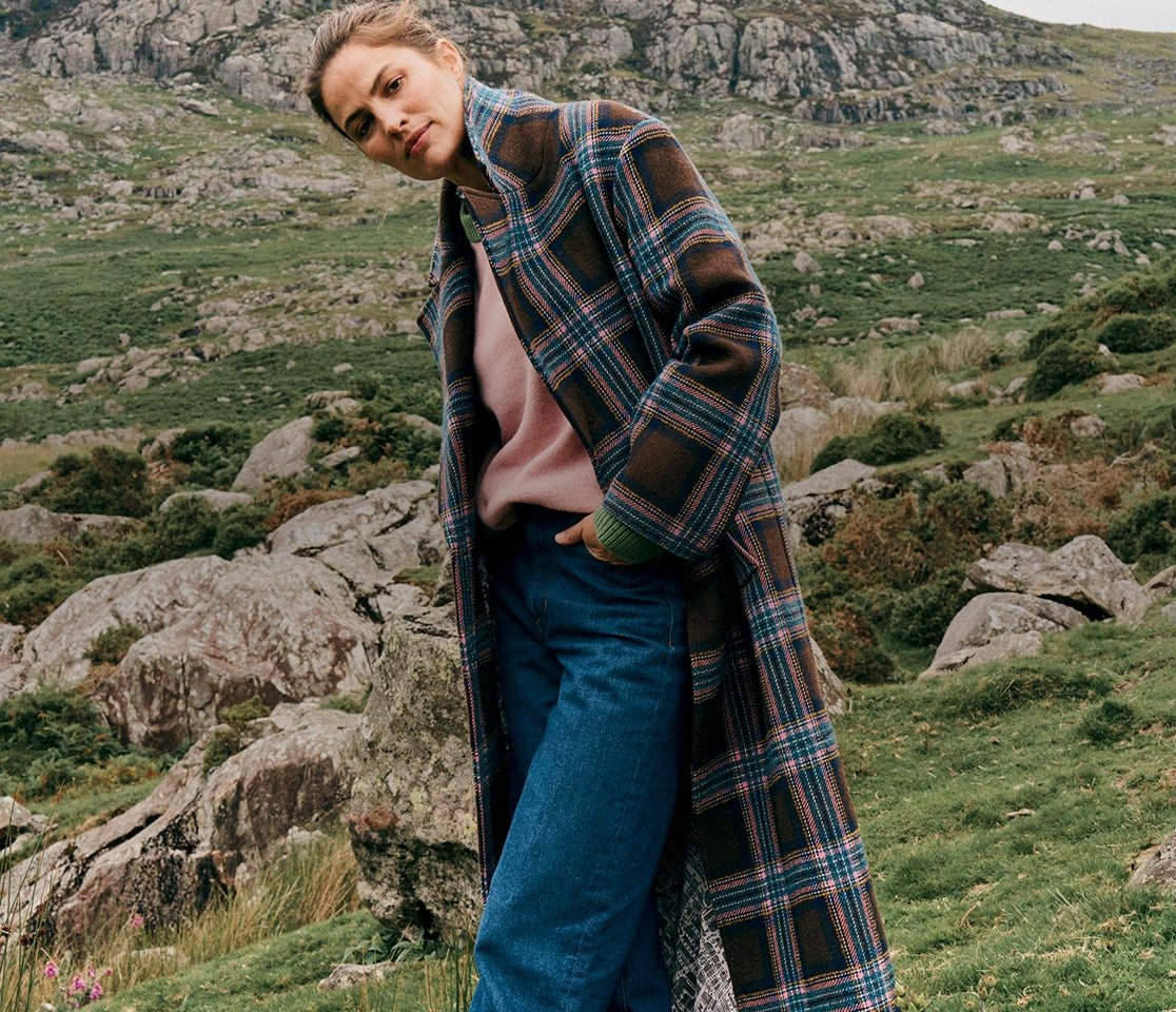 Person wearing a plaid coat in a natural landscape