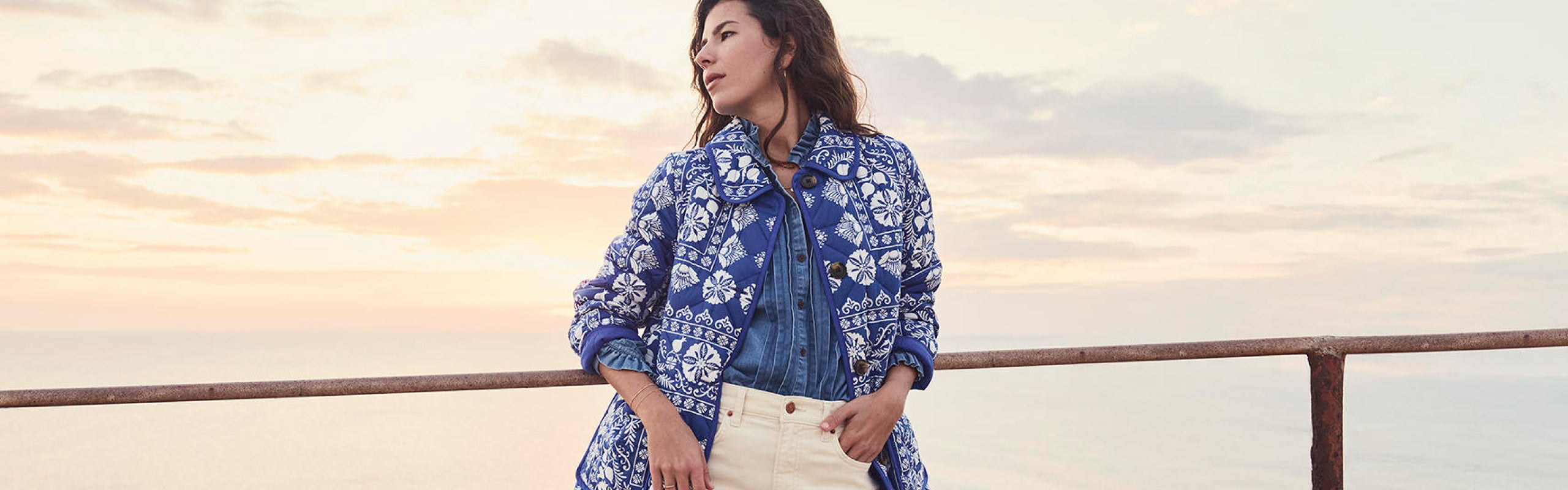 Woman on a cliff wearing Boden quilted coat