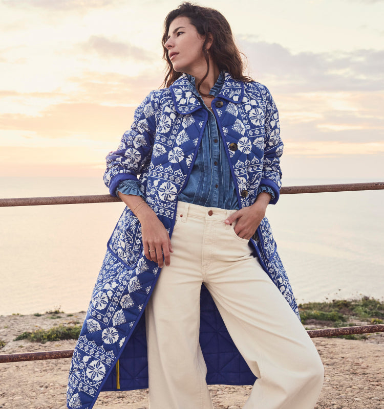 Woman on a cliff wearing Boden quilted coat