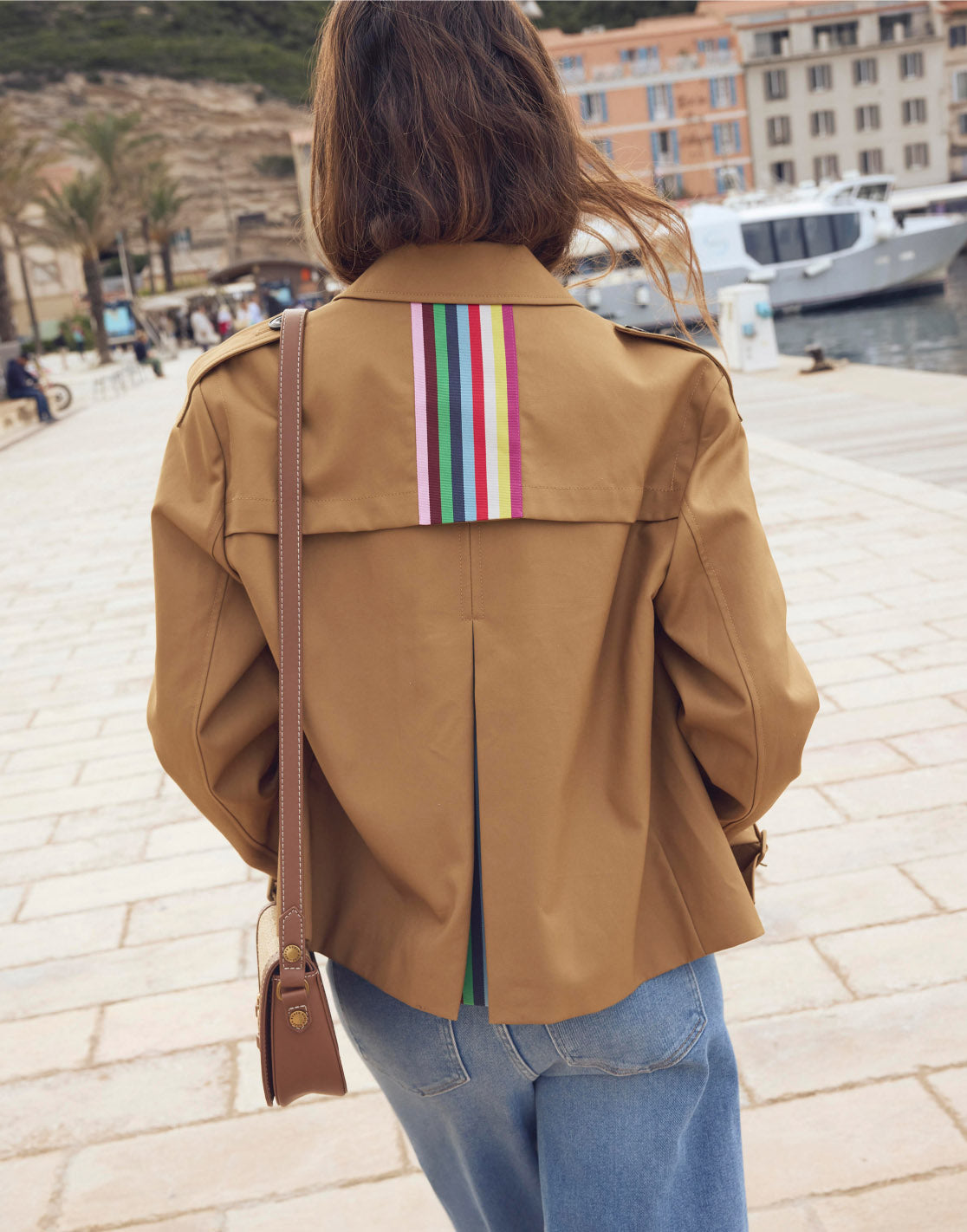 Woman showing the back of her Boden coat, linking to Mayfair Cropped Trench - Hazelnut Brown