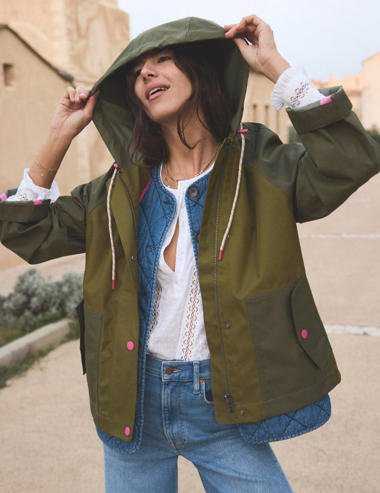 Woman putting up the hood of her coat, linking to Bode Cropped Raincoat - Khaki