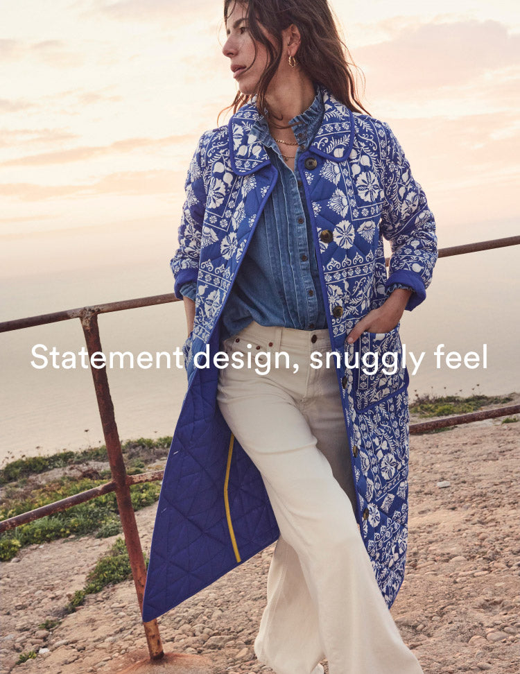 Woman wearing Boden quilted coat, caption "Statement design, snuggly feel", linking to Soft Quilted Coat - Bright Blue, Ornate Stripe